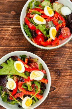 Biberli, domatesli, salatalıklı ve bıldırcın yumurtalı ev yapımı salata. Keto veya paleo diyeti.