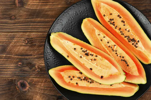 stock image Sliced fresh juicy papaya on the table. Space for text.