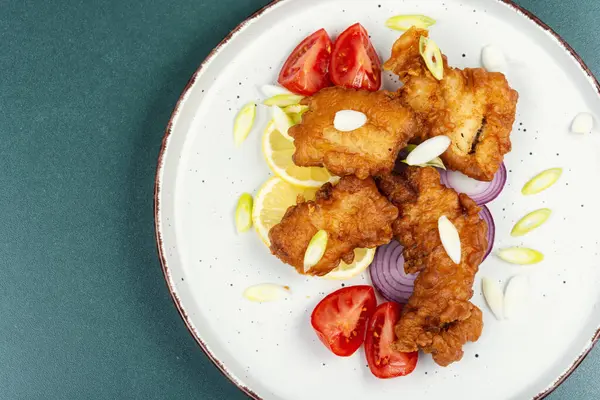 Lezzetli kızarmış balık parçaları tabakta. Metin için boşluk.