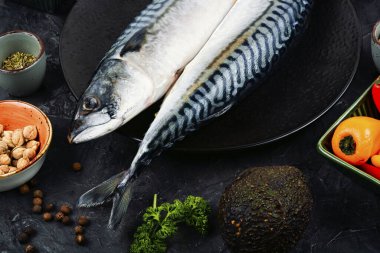 Taze uskumrular ve malzemeler açık gri masada. Uskumru balığı pişiriyorum..