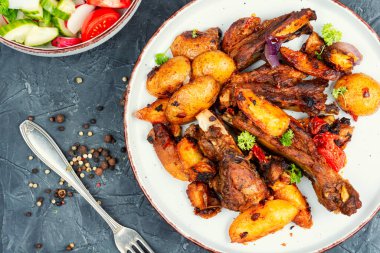 Kızarmış et, kemikli, beyaz tabakta, patatesli..