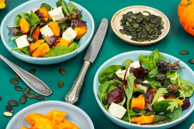 Hokkaido kabağı, peynir ve yeşilliklerle karıştırılmış yeşil salata. Sağlıklı ev yemekleri..