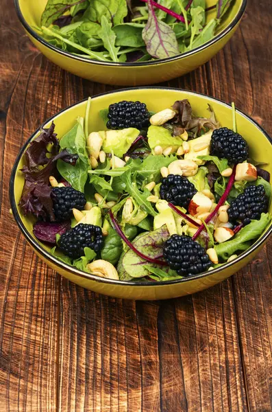 stock image Vitamin salad with blackberries, microgreens, avocado and pine nuts on wooden rustic background. Rustic style