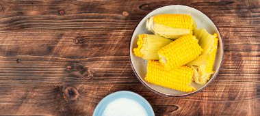 Ahşap arka planda kaynamış mısır. Lezzetli haşlanmış mısır. Metnin için boş yer.