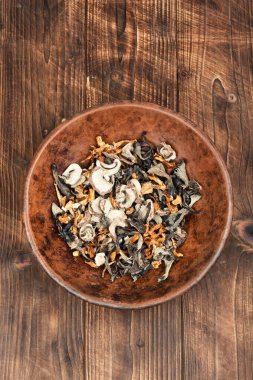 A vibrant array of dried mushrooms on a rustic wooden table clipart