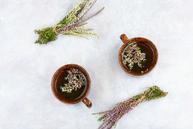 Sehpada bitki çayı ile birlikte cam çay fincanı. Bitkisel ilaçlar, şifalı bitkiler. Boşluğu kopyala.