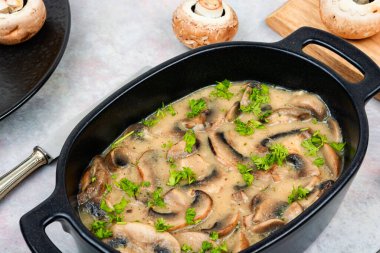 Krema sosu ve taze otlarla pişirilmiş mantarlar..