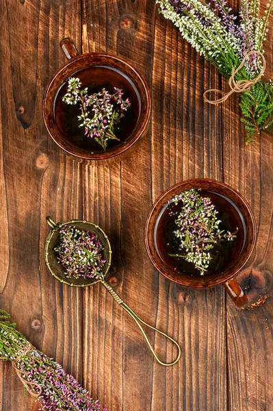 Taze kenevirli bitki çayı, homeopati. Tahta masada Heather çiçeği çayı.