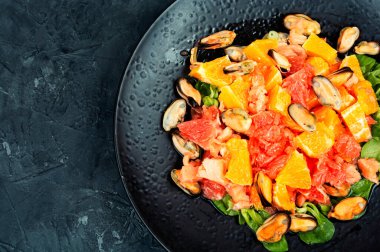 Greyfurtlu, portakallı ve midyeli deniz ürünleri salatası. Metin için boşluk.
