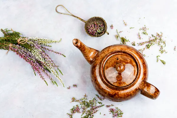 Cam bardakta Heather bitkisel çayı ve masada orman bitkileri. Sonbahar bitkilerinden çay. Phytotea.