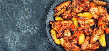 Mermer patates ve adaçayı ile taze pişmiş tavuk kanadı. Metin için boşluk.