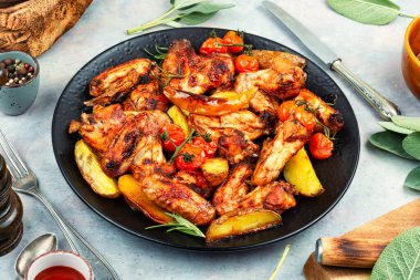 Kızarmış tavuk kanadı ve fırında patates. Barbekü..