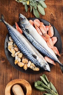 Taze uskumru balığı ya da pişmemiş Atlantik uskumrusu karides, karides, midye ve kırsal ahşap masada pişirmek için malzemeler. Kırsal biçim.