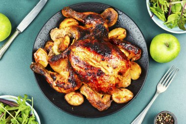 Taze pişmiş, çıtır çıtır, elmalı ızgara tavuk seramik bir tabakta sunuluyor. Düz yatıyordu