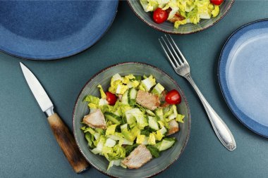 Salatalı yeşil salata, salatalık, domates ve et parçaları..