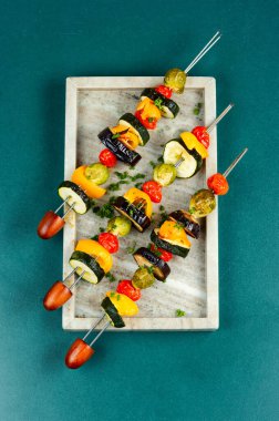 Vegetable vegetarian kebabs, tomatoes, cabbage, pepper grilled on skewers. Vegan food concept. Top view. clipart