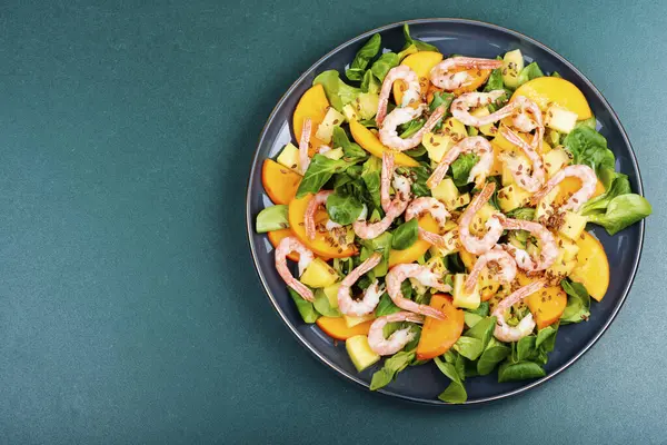 Lezzetli taze deniz ürünleri salatası, karides, hurma, kivi ve bitkilerle birlikte. Boşluğu kopyala.