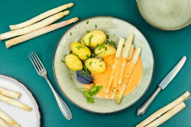 Haşlanmış beyaz kuşkonmaz ile Hollandaise sosu ve yeni patates, vejetaryen. Düz yatıyordu.