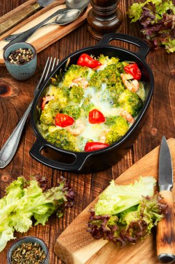 Kızarmış yeşil brokoli, karides, fırında sebze, güveç ve ahşap masa..