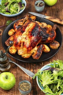 Sebzeli fırında tavuk ve kırsal ahşap masada elmalar..