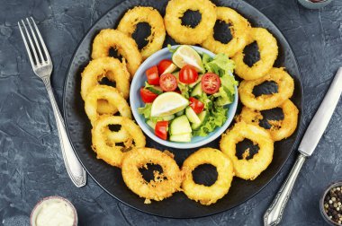 Soslu mürekkep balığı halkaları. Kızarmış kalamar halkaları, kalamar yemeği. Üst görünüm.