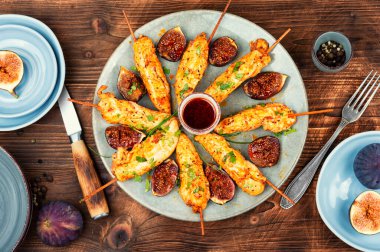 Tahta şişte tavuk eti ve ahşap arka planda incir. Tavuk şişi, tavuk kebabı..