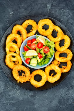 Soslu mürekkep balığı halkaları. Kızarmış kalamar halkaları, kalamar yemeği. Üst görünüm.