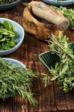 Pişirmek için taze otlar, nane, kekik, biberiye, adaçayı ve sade ahşap masa üzerinde baharat..