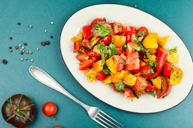 Healthy tomatoes salad, a bowl of vibrant, fresh salad with mixed greens, cherry tomatoes. Copy space.