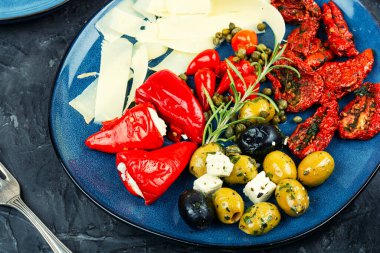 Peynir çeşitleri, Akdeniz zeytinleri, güneşte kurutulmuş domatesler, siyah ve yeşil zeytinler ve yumuşak peynirle doldurulmuş marine edilmiş kırmızı biberler..