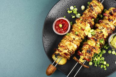 Izgara patates ve peynirli pastırma şişi, şiş soslu soslar. Yaz barbeküsü. Metin için boşluk.