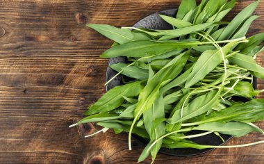 Çiğ organik yeşil rampalar, yeşil soğan filizleri, bitkiler. Ayı pırasası, yabani sarımsak.