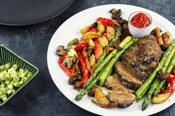 Baharatlı ızgara ördek göğsü ve kızarmış sebze ve kuşkonmaz, sağlıklı yemek ve barbekü kavramı..