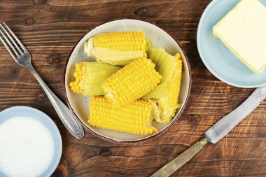 Ev yapımı altın mısır koçanı tereyağı ve tuzlu köy ahşabı masa..