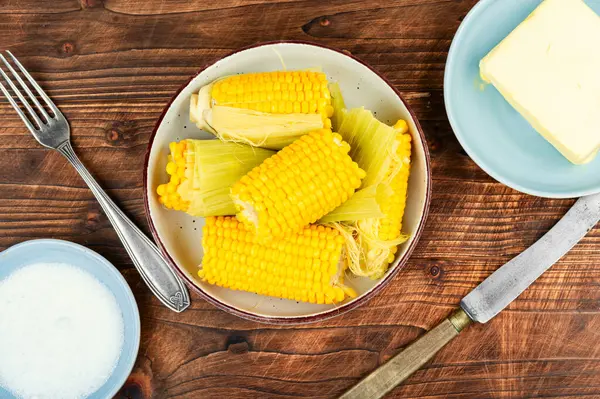 Ev yapımı altın mısır koçanı tereyağı ve tuzlu köy ahşabı masa..