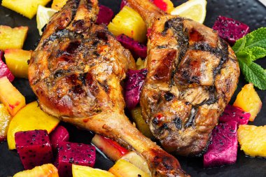 Meyve salamurasında pişirilmiş iki ördek bacağı. Yemek fotoğrafçılığı. Makro