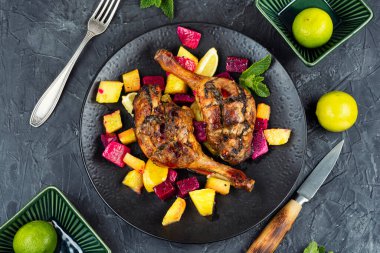 Beton mutfak masasında tropikal meyvelerle servis edilen ördek ya da kaz bacağı. Genel Görünüm.