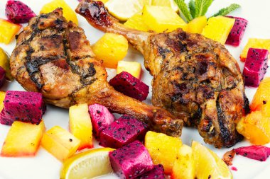 Limon, ananas ve ejderha meyvesiyle servis edilen lezzetli pişmiş ördek bacağı..