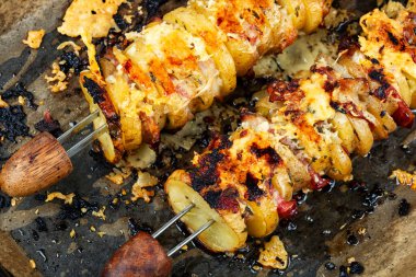 Pastırmalı dilimlenmiş patates ve şiş soslu leziz bir tabak. Şiş kebap şiş. Yemek fotoğrafçılığı.