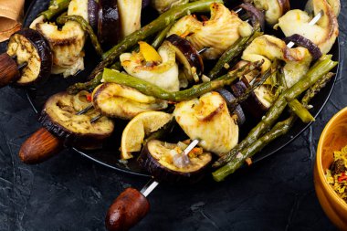 White fish fillet with asparagus and vegetables on skewers. Barbecue seafood.