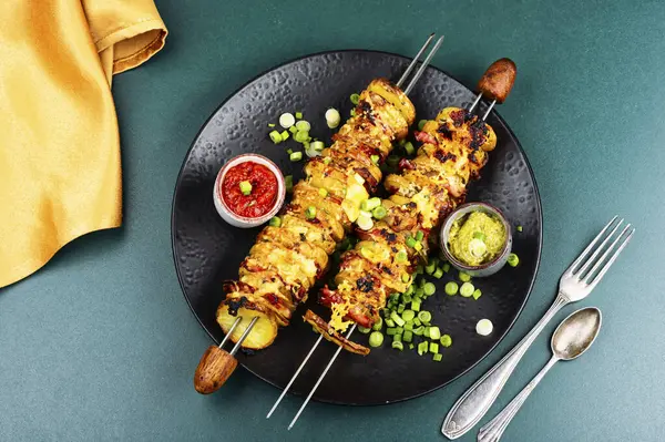 Kızarmış ya da ızgara pastırma, kızarmış patates ve soslu et şişleri. Düz yatıyordu