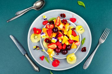 Canlı meyve salatası, çilek, kivi, portakal, kiraz ve yenilebilir çiçekler. Genel Görünüm.