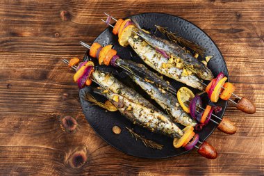 Pişmiş sardalya şişleri. Balık kebabı, şişte sardalya, ahşap kırsal alanda barbekü..
