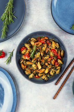 Masada sebze sosu olan bir kasede nefis pişmiş midyeler.