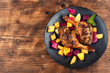 Ananas, limon ve ejderha meyvesiyle pişirilmiş ördek eti, ahşap arka planda pişmiş ördek bacağı. Metin için boşluk.