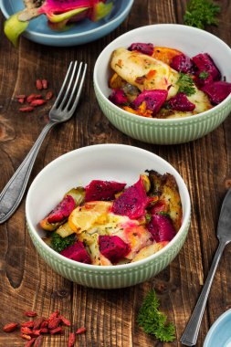 Pitahaya ile pişirilmiş beyaz balık, meyveli balık filetosu. Kırsal ahşap masada kızarmış balık..