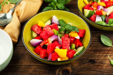 Karpuz parçaları ve ahşap kırsal arka planda salatalık dilimlerinden oluşan canlı salata..