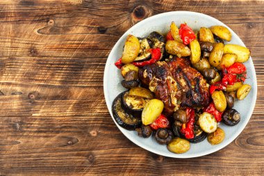 Ahşap yüzeyde sebzelerle fırında pişirilmiş domuz rostosu. Metin için boşluk.