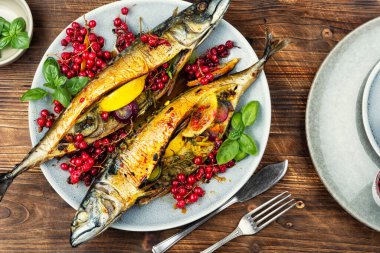 Limon, soğan ve böğürtlen üzümlü ev yapımı fırında uskumru. Ahşap yüzeyde deniz ürünleri. Genel Görünüm.