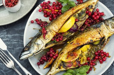 İştah açıcı ve aromatik uskumru balığı fırında limon ve kırmızı üzümle pişirilmiş..